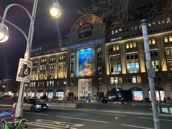 The Kaufhaus des Westens department store, a seven-story building that takes up a full block, with a giant culorful banner in the center.