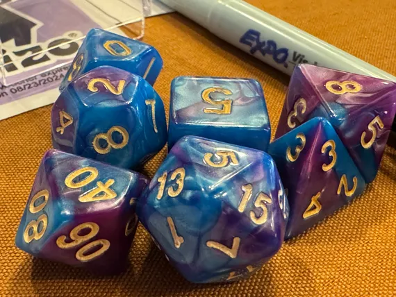 A set of seven swirled blue and purple dice.