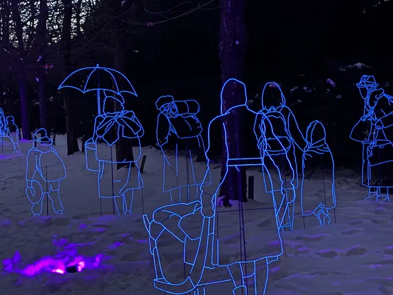 Wireframes of people carrying their possessions on foot glow blue against the snow.