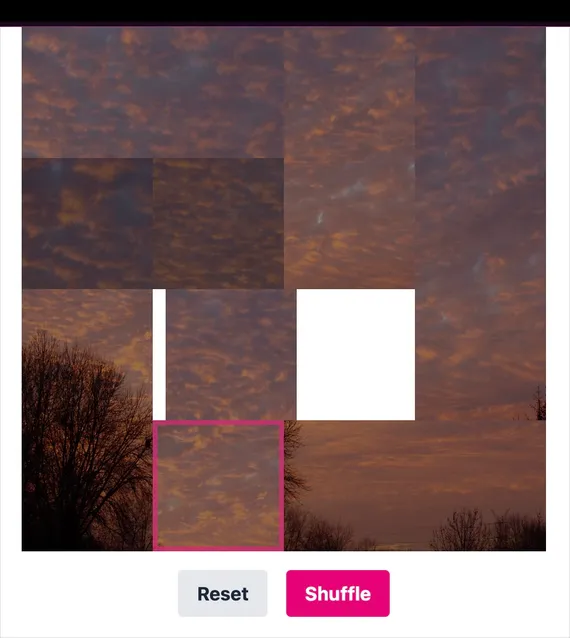 A square sliding block puzzle showing a jumbled skyscape, with Reset and Shuffle buttons.